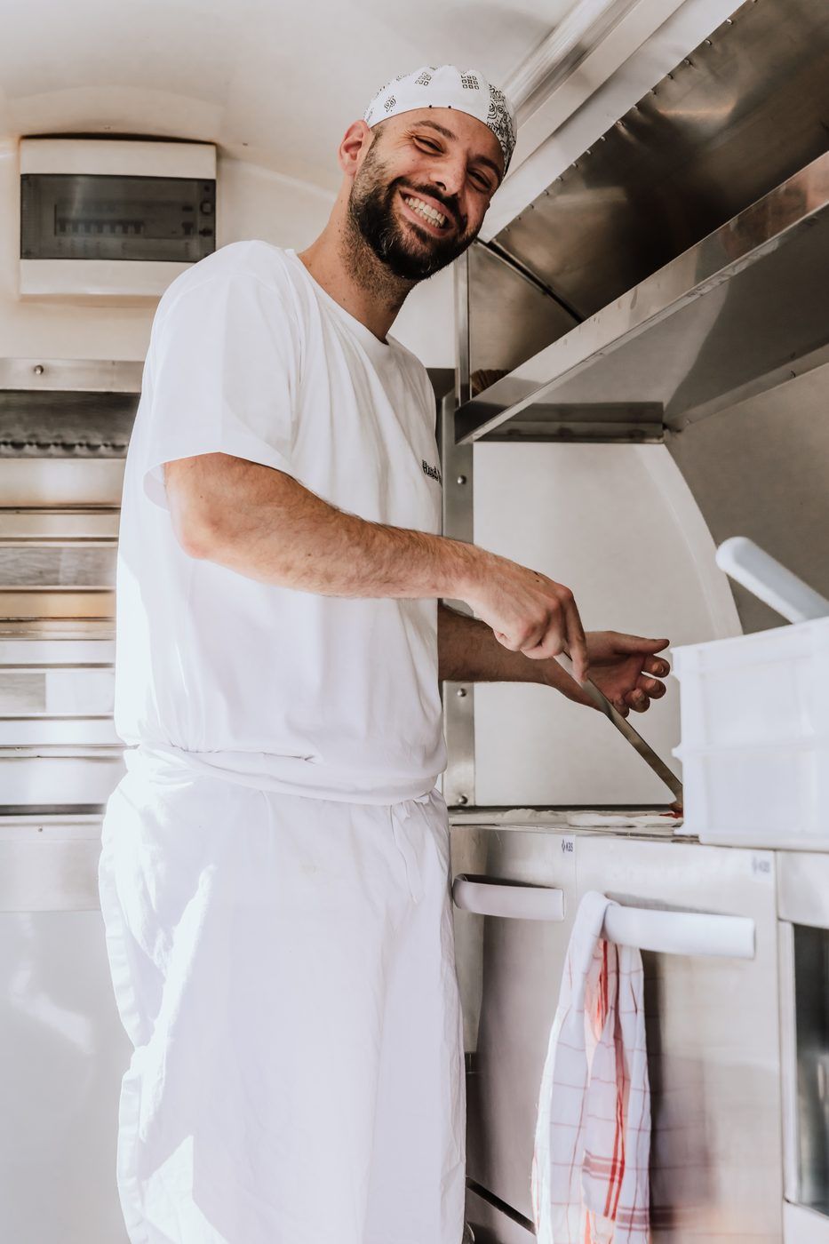 Angelo Salerno lacht beim Belegen einer Pizza